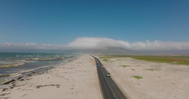 继续追踪沿海公路上行驶的车辆。晴天，海浪在沙滩上翻滚. — 图库视频影像