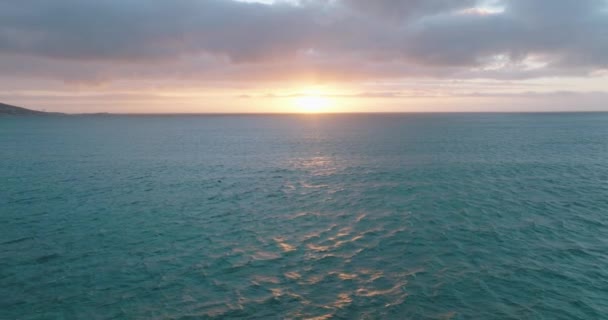 Voe para trás acima da água do mar ondulada à noite. Observação de baleias contra o pôr do sol romântico. — Vídeo de Stock