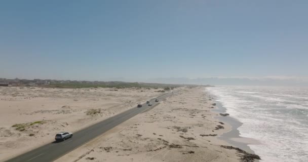 阳光明媚的日子,海滨的沙滩上有晴朗的天空.沿海道路上的交通情况. — 图库视频影像