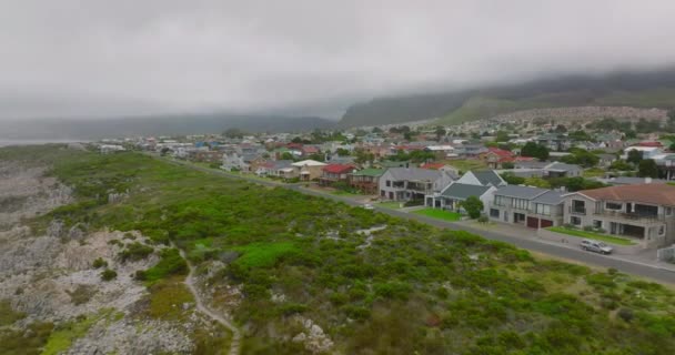Familiehuizen in een woonwijk. Achterwaarts onthullen van de zeekust met grote golven en spetterend water. — Stockvideo