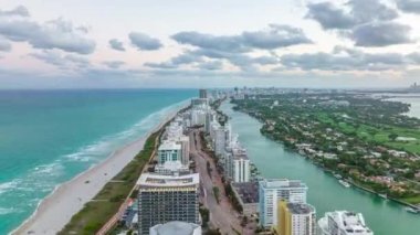 İleri doğru deniz kenarındaki yüksek binaların üzerinden uçar. Gece karanlığında çok şeritli yol boyunca otellerin ya da apartmanların yüksek süratli görüntüsü. Miami, ABD