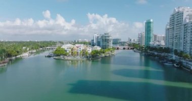 Rıhtımdaki yüksek apartmanların tersten görünüşü. Şehrin sakin su yüzeyinin üzerinde uç. Miami, ABD