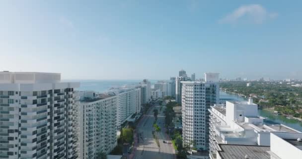 Wielopasmowa droga bagażowa wiodąca pomiędzy wysokimi luksusowymi budynkami apartamentowymi wzdłuż wybrzeża morskiego. Przód wznosi się ponad rozwój miasta. Miami, USA — Wideo stockowe
