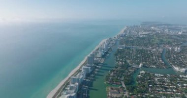Okyanus kıyısının, sahil boyunca sıra sıra yüksek apartman binalarıyla çekilmiş panoramik görüntüleri. Miami, ABD