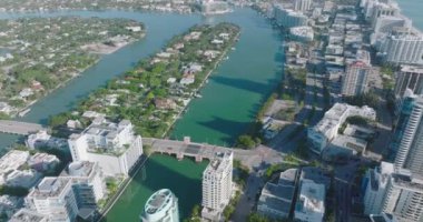 Kentsel çevredeki yol ve köprülerin hava görüntüleri var. Yüksek binalar ve aile evleri karışımı. Miami, ABD