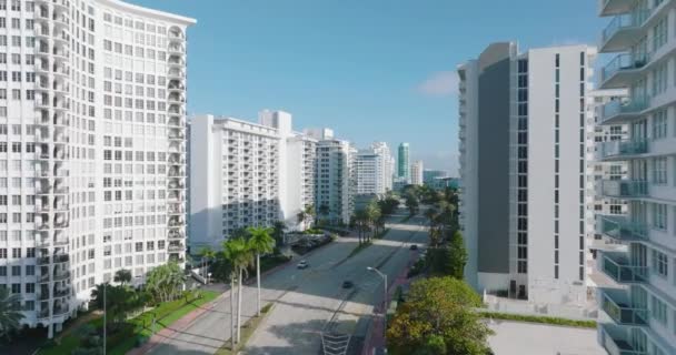 Modern kentsel çevredeki uzun binalar ya da oteller. Geniş ana yol boyunca yüksek katlı kasaba inşaatı. Miami, ABD — Stok video
