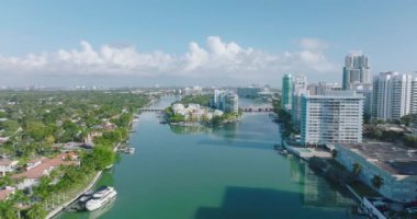 Su yüzeyinde geriye doğru uç. Bir bankadaki modern yüksek apartmanlar ve karşıdaki lüks konutlar. Miami, ABD