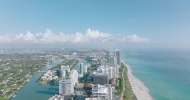 Deniz kıyısındaki kentsel ilçedeki yüksek modern binaların hava panoramik görüntüleri. İleri, kasabanın üstünden uçar. Miami, ABD