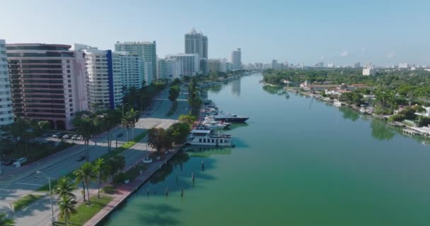 Moderne lange stadsontwikkeling, meerbaans weggetje omzoomd door palmbomen en turquoise water in kreek. Miami, Verenigde Staten — Stockvideo