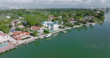 Rıhtımdaki lüks konutların kaydırak ve tava görüntüleri. Yeşil bitki örtüsüyle çevrili büyük evler. Miami, ABD