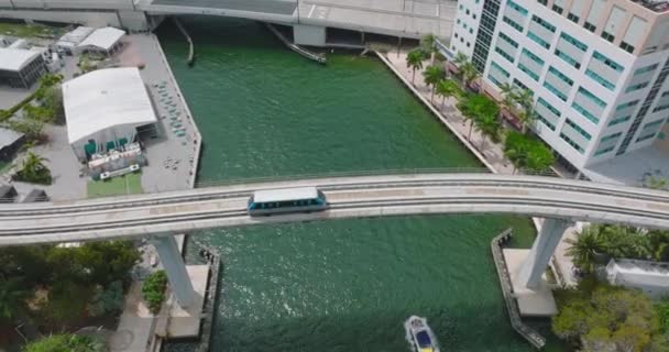 Metromover 'ın aracının dalgalı suyun üzerinde uzun bir köprüde sürüşünün izini sürüyorum. Tekne nehirde ilerliyor. Miami, ABD — Stok video