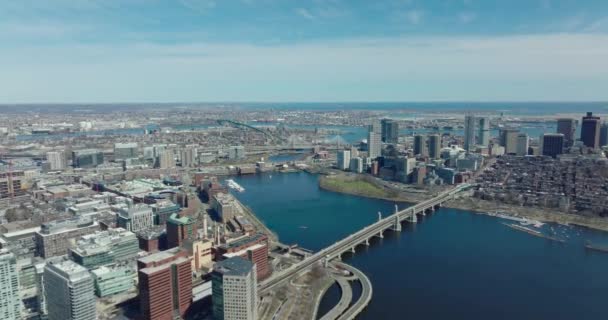 Forwards fly above waterfront. Long bridge over wide Charles river at water dam in city. Urban boroughs on banks. Boston, USA — ストック動画