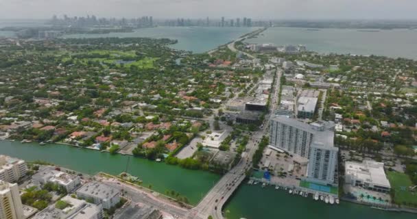 Vysoký úhel pohledu na obytné čtvrti s domy obklopenými stromy a zelenou vegetací. Nakloňte se a odhalte městskou krajinu. Miami, USA — Stock video
