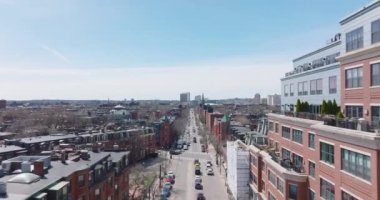 Büyük şehirde caddenin üzerinde ilerliyorlar. Kentsel çevredeki yol kenarındaki evlere kırmızı tuğlalı cephe. Boston, ABD