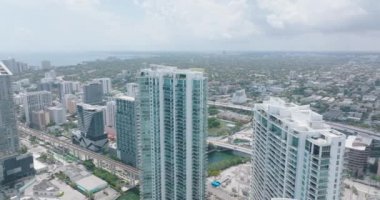Modern yüksek binaların inanılmaz hava manzarası. Nehir çevresindeki şehir merkezindeki kuleler ve arka plandaki kentsel mahalleler. Miami, ABD
