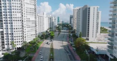 Lüks bir yerleşim bölgesindeki yüksek apartman binalarının arasından geçen geniş, çok şeritli bir yolun havadan görünüşü. Miami, ABD