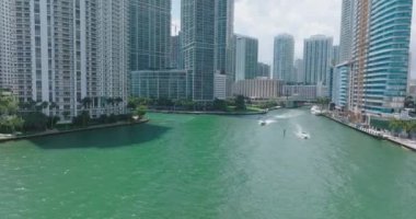 Nehir boyunca modern yüksek katlı lüks şehir binaları. Suda yüzen sürat tekneleri. Miami, ABD