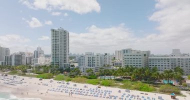 Deniz kıyısındaki modern çok katlı apartmanlar ya da oteller. Geriye doğru uzanan kum plajı. Miami, ABD