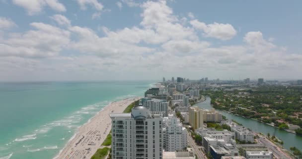 Modern gebouw aan zeekust. Luchtfoto van hoogbouw appartementencomplex nabij zandstrand. Miami, Verenigde Staten — Stockvideo