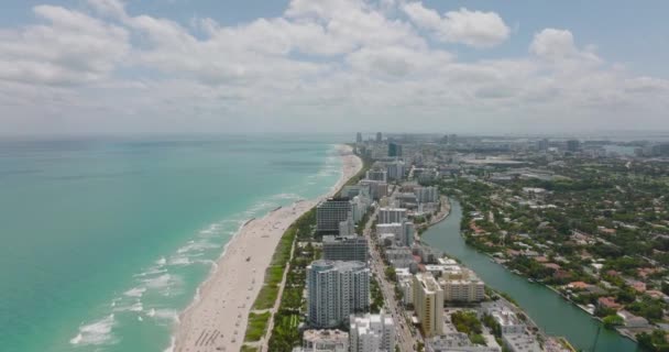 Aerial panoramic descending footage of urban borough on sea coast. Stripe of multistorey apartment buildings and hotels along beach. Miami, USA — Video