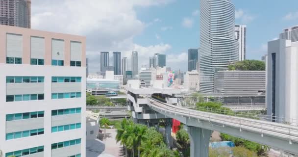 Parkın üstündeki sütunları kullanarak Metromover pistinin üzerinden uç. Metropolis 'te modern yolcu taşıma aracı. Miami, ABD — Stok video