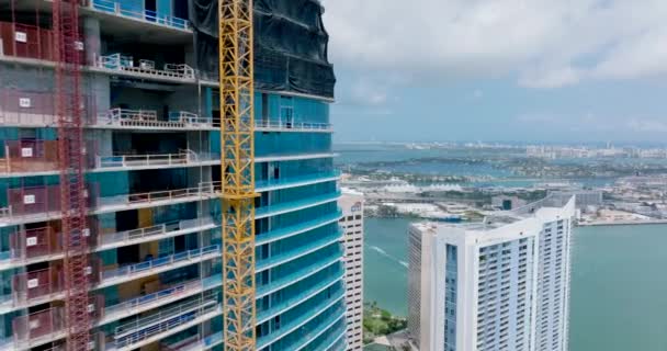 İnşaat halindeki gökdelende uçmak. Sahilin, adaların ve deniz gezisi terminalinin panoramik manzarası ortaya çıkıyor. Miami, ABD — Stok video