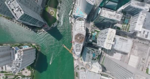 自上而下的上升镜头的未来城市与高楼大厦。在水面上经过摩天大楼的船只。美国迈阿密 — 图库视频影像