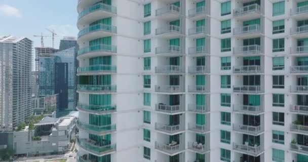 Levantamento tiro de fachada prédio de apartamentos com janelas e varandas. Revelando bairro urbano moderno. Miami, EUA — Vídeo de Stock
