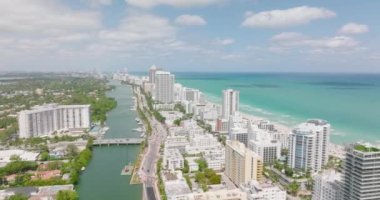 Deniz kıyısındaki yüksek binaların üzerinden uç. Şehir merkezinden geçen otoyolda trafik vardı. Tropikal varış noktasının inanılmaz panoramik çekimi. Miami, ABD