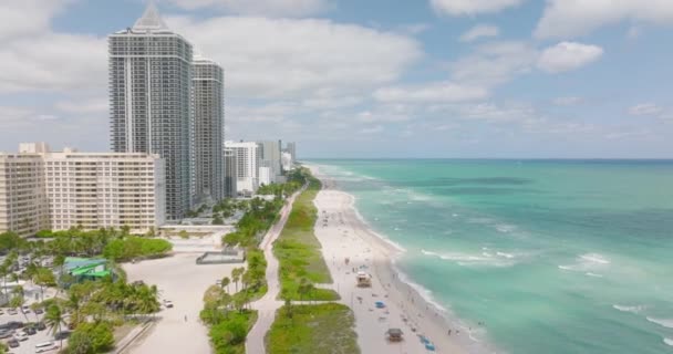 Fantastisk utsikt över havskusten. Milda vågor tvättar sandstrand kantad av lägenhetsbyggnader och hotell. Miami, USA — Stockvideo