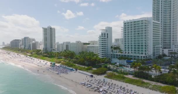 Flygfoto över tropisk semesterort. Slide och panorera bilder av sandstrand kantad av palmer och hotell. Miami, USA — Stockvideo