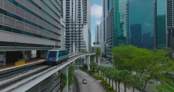Şehir merkezindeki modern gökdelenlerle çevrili metro raylarında ilerleyen Metromover aracının takibi. Miami, ABD — Stok video