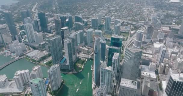 High angle view of group of downtown skyscrapers. Tilt up reveal of town development in residential neighbourhoods in background. Miami, USA — ストック動画