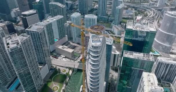 Vista de ángulo alto del sitio de construcción de rascacielos. Vista de arriba hacia abajo de la ciudad moderna. Superficie de agua brillante. Miami, Estados Unidos — Vídeos de Stock