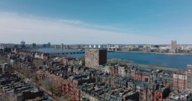 Şehir dışındaki yerleşim birimlerinin üzerinde ilerliyorlar. Charles River rıhtımında yoğun bir yol var. Boston, ABD