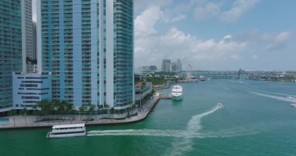 Tropikal bölgedeki lüks şehir bölgesinde park ve rıhtım. İleri, modern yüksek binalar ve büyük yatlar boyunca uçar. Miami, ABD — Stok video