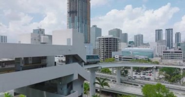 Metromover vagonu modern şehrin üst otobanındaki yüksek raylarda hareket ediyor. Toplu taşıma konsepti. Miami, ABD