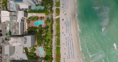 Tropikal varış noktasındaki deniz kıyısındaki otellerin ve plajların kuş bakışı görüntüleri. Bulutlar tarafından gölgelenmiş. Miami, ABD