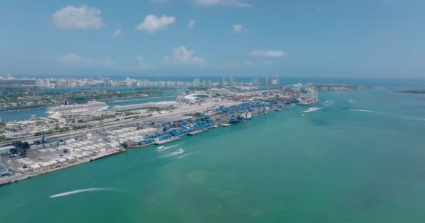 Rijen containers gestapeld in de haven, Grote zee cruiseschip afgemeerd op passagiersterminal. Voorwaarts vliegen boven het wateroppervlak. Miami, Verenigde Staten — Stockvideo