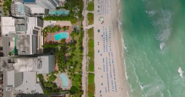 Birds eye shot de hoteles y playa en la costa del mar en destino tropical. Sombreado por nubes. Miami, Estados Unidos — Vídeos de Stock