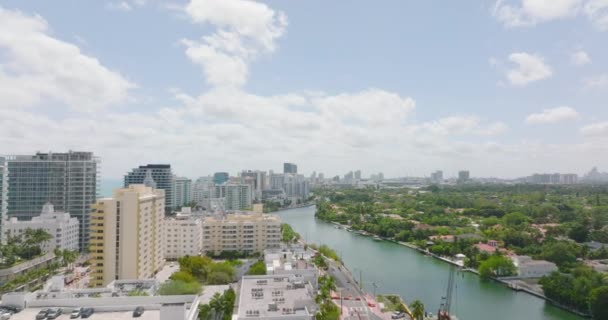 Nehir boyunca lüks evler ve apartmanlar. Forvetler tropik varış noktasında şehir merkezinin üzerinde uçar. Miami, ABD — Stok video