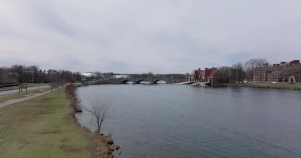 Winter or early spring landscape in city. Forwards fly above Charles river at Weld Boat House. Vehicles driving on Anderson Memorial Bridge. Boston, USA — Vídeo de stock
