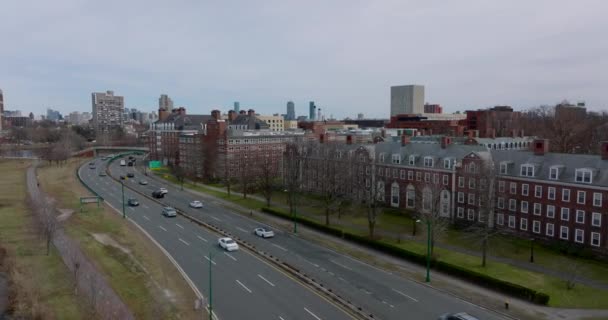 Ocupada carretera de varios carriles que conduce en la costa alrededor del complejo universitario de Harvard. Edificios clásicos de ladrillo rojo. Boston, Estados Unidos — Vídeo de stock