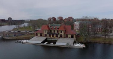 Charles nehri kıyısındaki Weld Boat House 'un kaydırak ve pan görüntüsü. Yolda giden araçlar ve eski Anderson Memorial Köprüsü. Boston, ABD