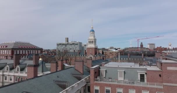 Fly over roofs with chimneys. Historic buildings of Harvard University. Heading towards tall white tower. Boston, USA — Vídeos de Stock