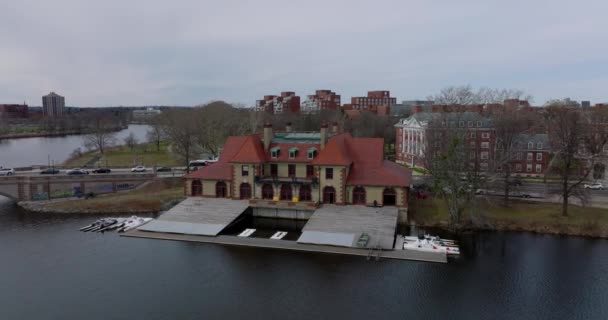 Slide and pan shot of Weld Boat House on Charles river waterfront. Vehicles driving on road and old Anderson Memorial Bridge. Boston, USA — ストック動画