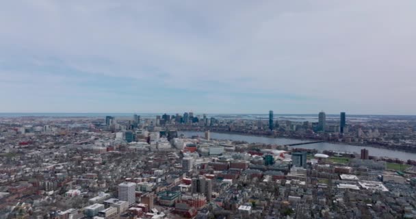 Fly above large city. Wide river flowing through metropolis. Evening aerial shot of town development. Boston, USA — Vídeo de stock