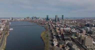 Şehir manzarasının sinematik hava görüntüsü. Charles Nehri Havzası 'nın geniş su yüzeyi. Arka plandaki modern yüksek katlı ofis binaları. Boston, ABD