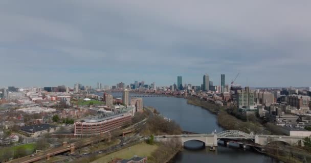 Aerial descending footage of bridge over Charles river and buildings on waterfronts. Downtown skyscrapers in distance. Boston, USA — Vídeo de stock