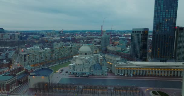 Воздушный слайд и панорамный снимок Первой Церкви Христа с большим куполом. Сакральная достопримечательность вокруг современного небоскреба в центре города. Город в сумерках. Бостон, США — стоковое видео